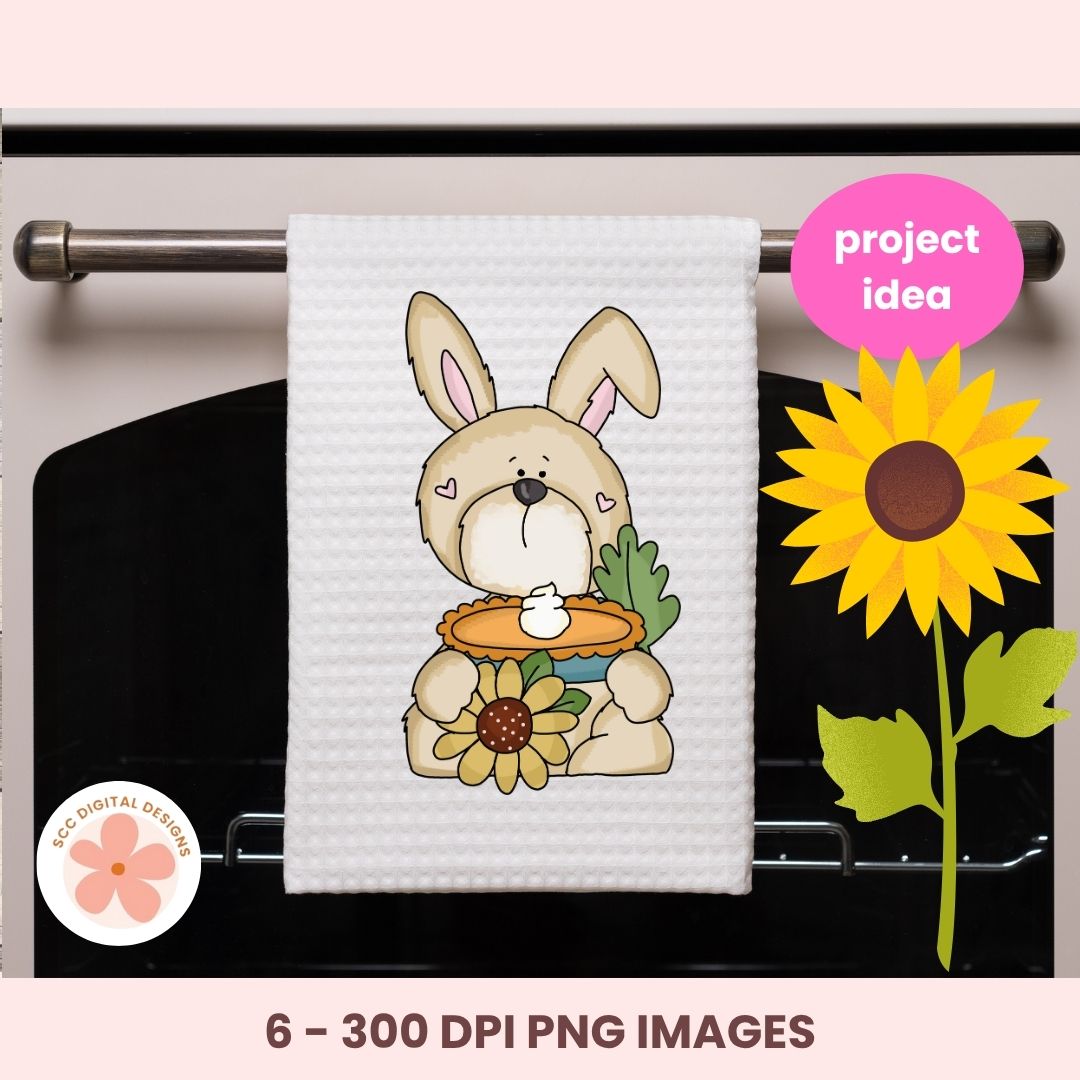 A white waffle-knit kitchen towel hanging on an oven rack, printed with a cartoon bunny holding a sunflower and a pie. The image includes a pink 'project idea' badge, a '6 - 300 DPI PNG IMAGES' label, and a 'KCC Digital Designs' logo.