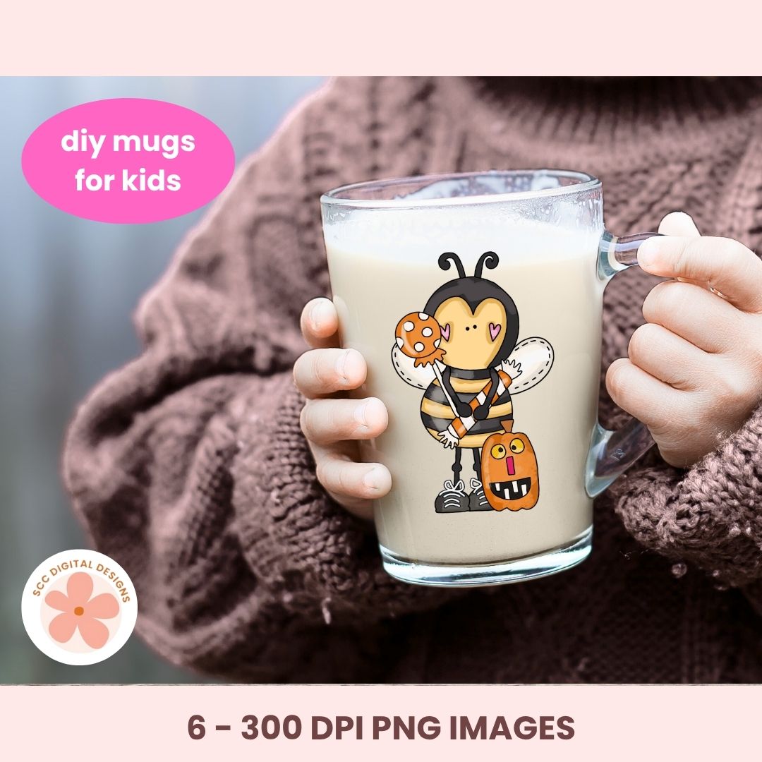 A person in a brown knit sweater holds a clear glass mug filled with a light beige drink. The mug has a cartoon bee character printed on it, holding a cookie and a pumpkin.