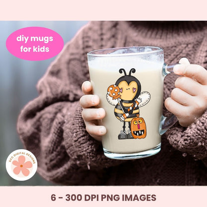 A person in a brown knit sweater holds a clear glass mug filled with a light beige drink. The mug has a cartoon bee character printed on it, holding a cookie and a pumpkin.