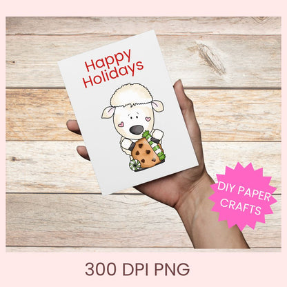 A hand holds a white greeting card with the text 'Happy Holidays' and a cartoon sheep holding a cookie, shown against a rustic wood background. A pink starburst says 'DIY PAPER CRAFTS' and text at the bottom reads '300 DPI PNG'.