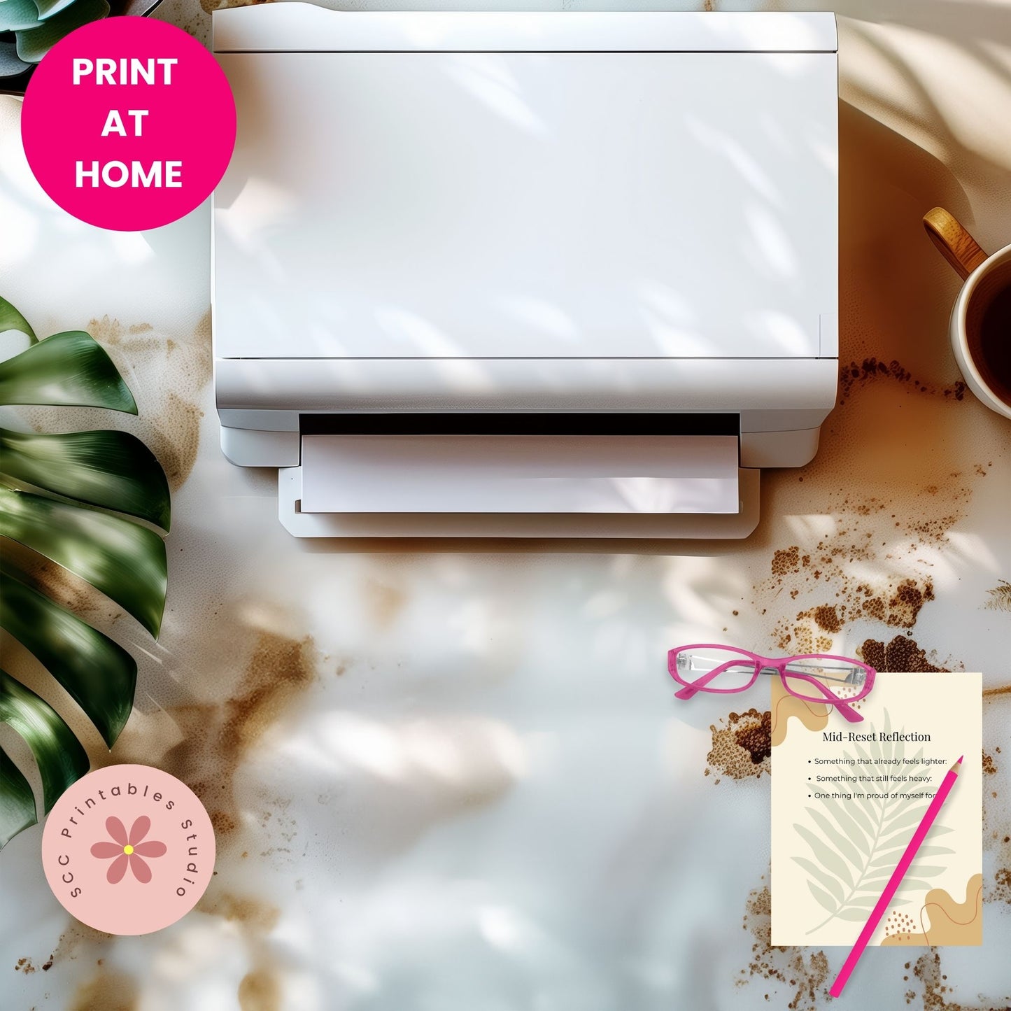 White printer on a desk with a mug, plant, and printed sheet of paper.