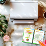 White printer on a desk with coloring books and markers