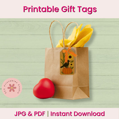 A brown kraft paper gift bag with twine handles and a decorative printed window tag, shown with yellow tissue paper and a red heart-shaped prop on a pale green wood-plank background. Pink text at the top and bottom reads 'Printable Gift Tags' and 'JPG & PDF | Instant Download.