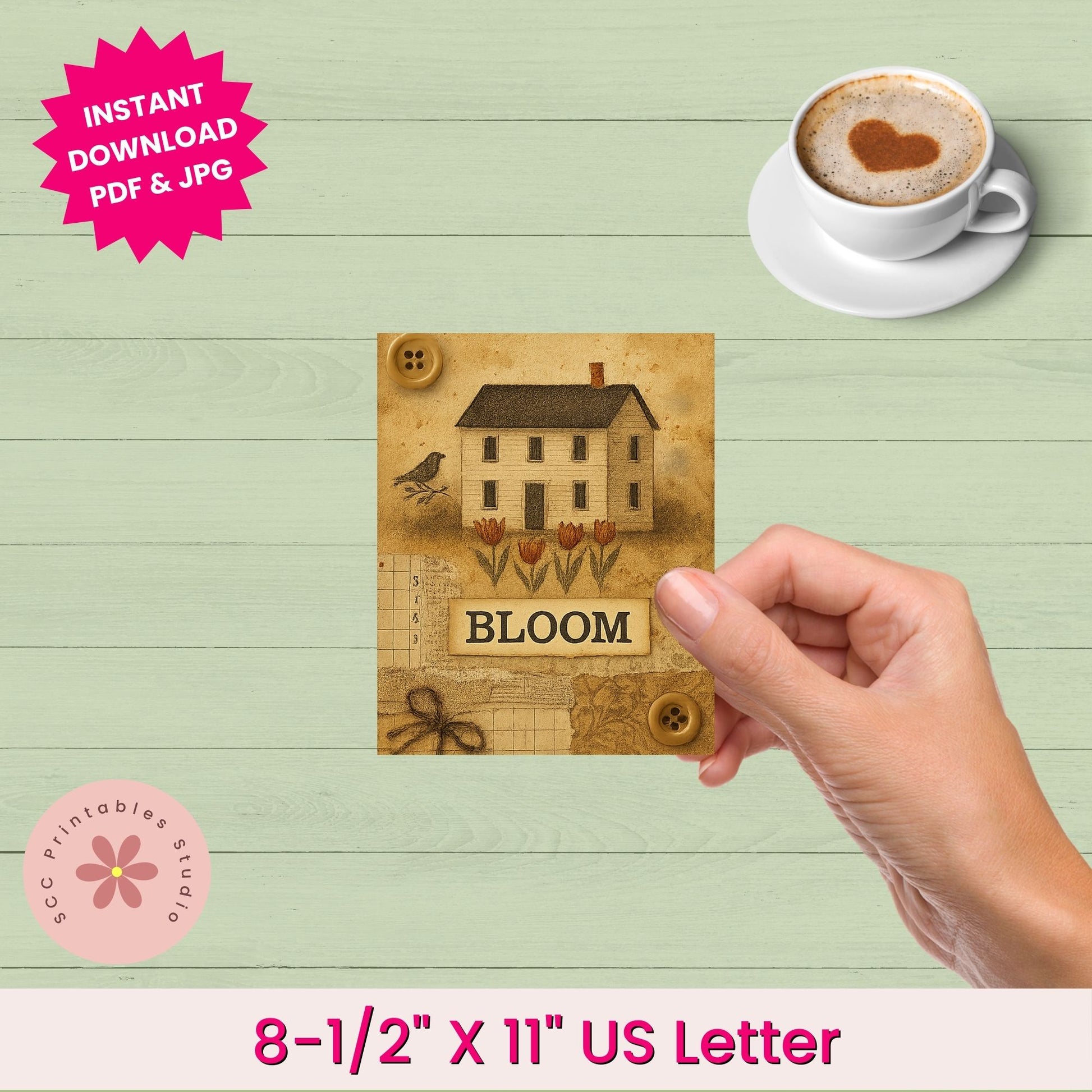 Hand holding a wooden sign with a house and 'BLOOM' text, next to a cup of coffee on a wooden surface.