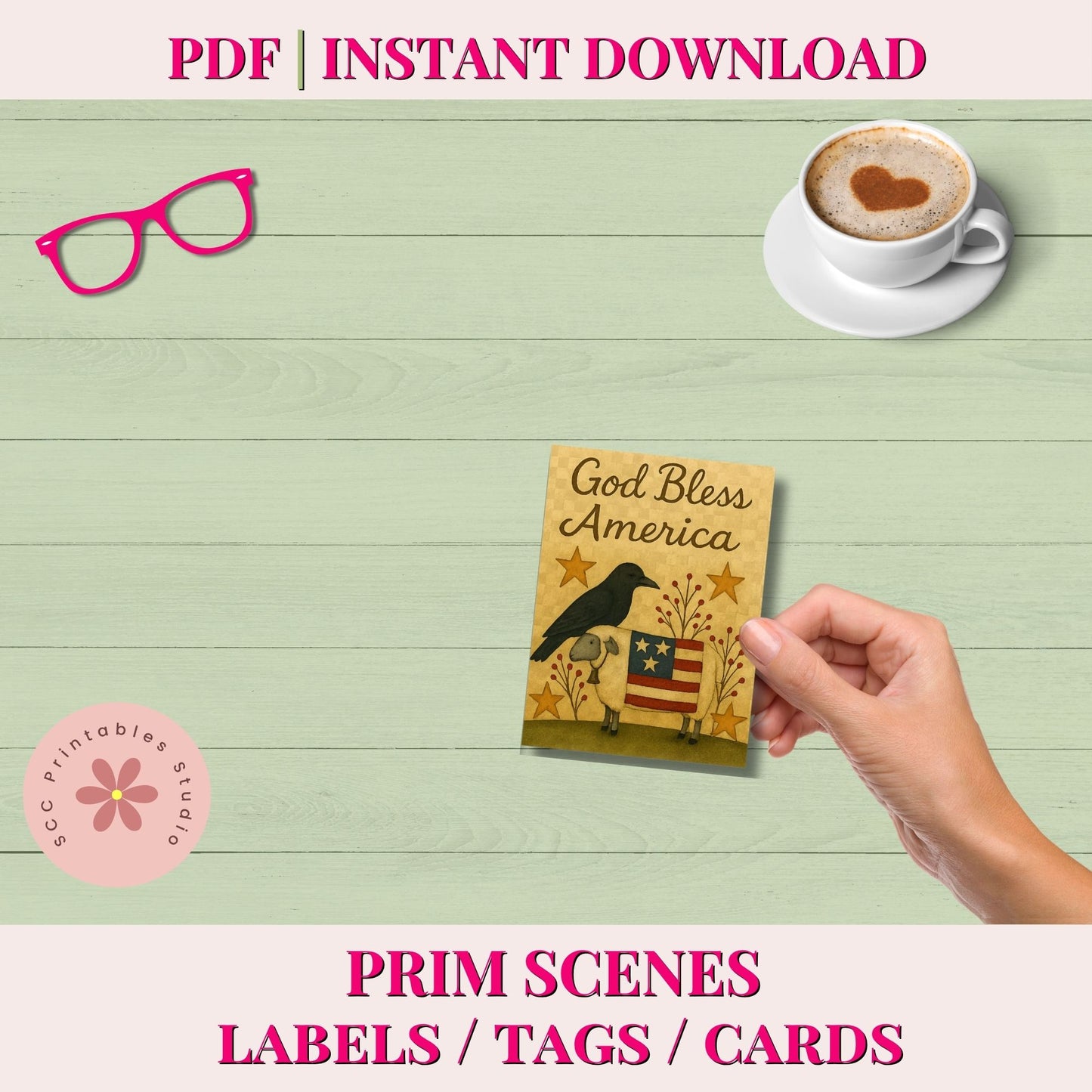 A promotional graphic for a PDF instant download listing. The image shows a hand holding a small printed card that reads 'God Bless America' with a raven and American flag design, set against a light green wood-plank background.