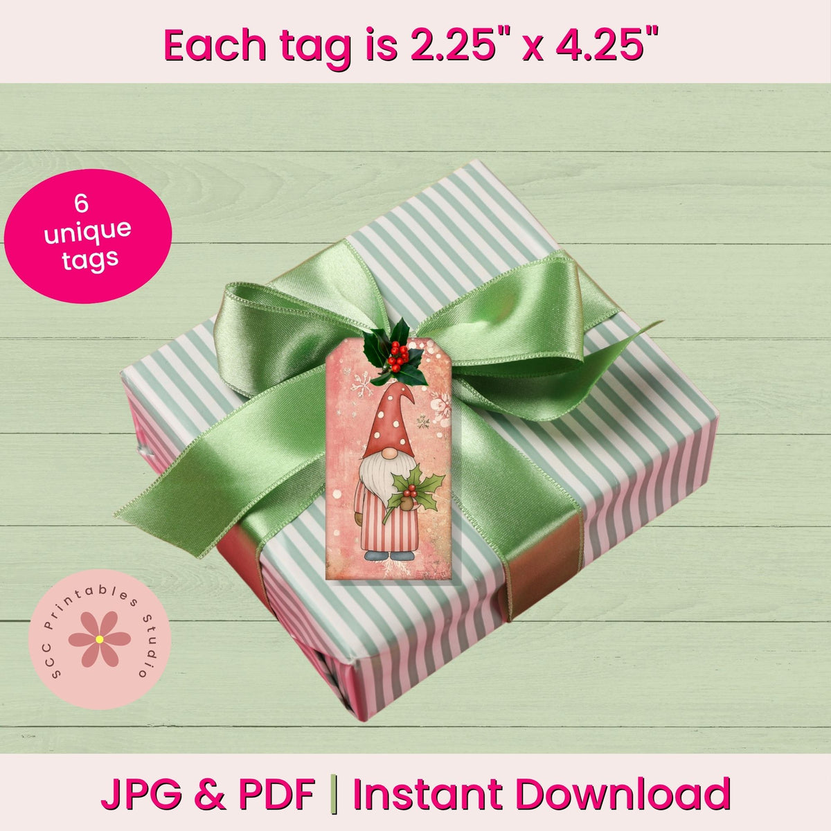 A gift box wrapped in pale green and white striped paper with a large mint green satin ribbon and a decorative holiday gnome gift tag. Pink text at the top says each tag is 2.