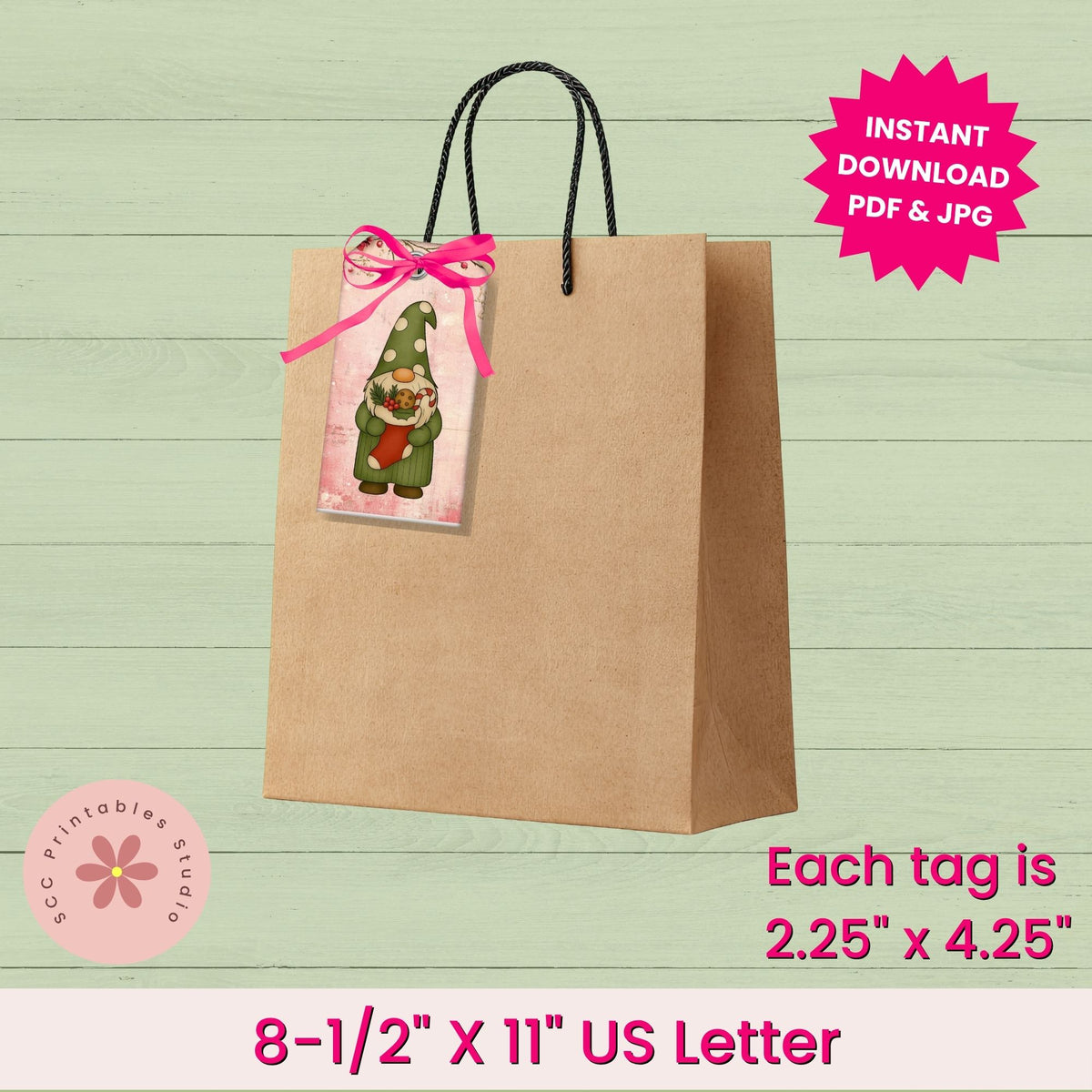 A printable gift tag template shown attached to a brown paper bag with black handles, on a pale green wood-plank background. The tag features a cartoon gnome wearing a green hat and red scarf.