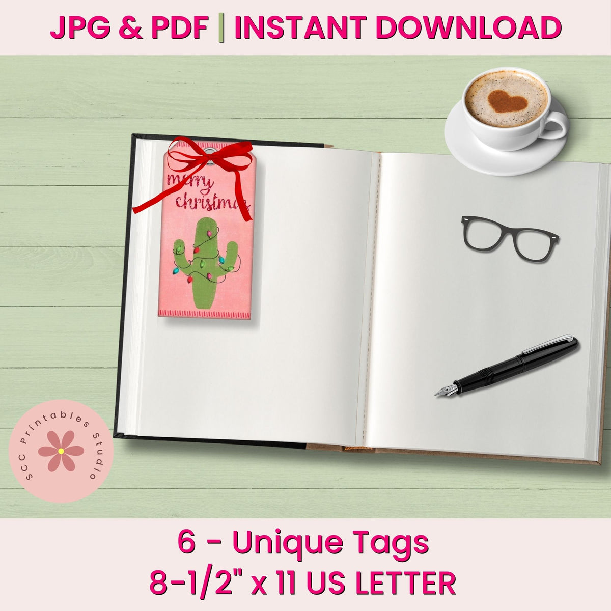 A promotional mockup for printable Christmas tags, showing an open notebook with a pink tag attached on the left page. The tag has a red ribbon bow and a green cactus illustration with the words 'merry christmas.