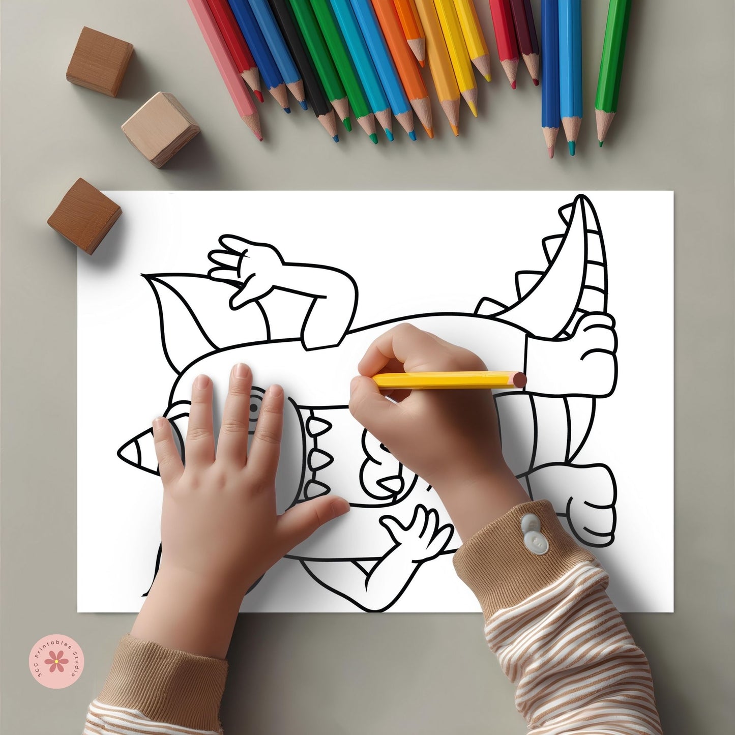 Child coloring a dinosaur picture with colored pencils on a gray surface