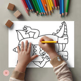 Child coloring a dinosaur picture with colored pencils on a gray surface