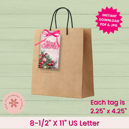 A kraft paper gift bag with black twisted handles on a light green wood-plank background. A Christmas-themed hang tag with a pink bow is attached to the bag.