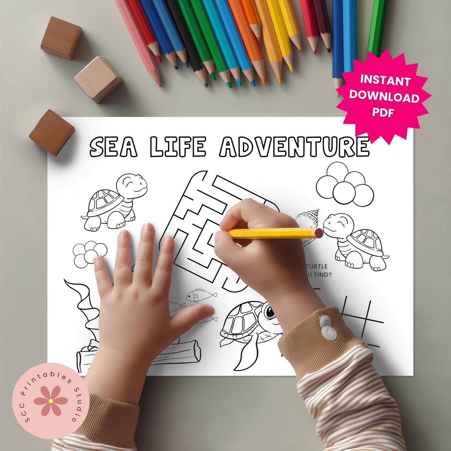 Coloring sheet titled 'Sea Life Adventure' with a hand holding a pencil, surrounded by colored pencils and blocks.