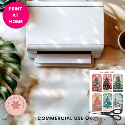 A white rectangular printer or label printer shown from above on a marble-like surface with shadows, alongside a pink 'PRINT AT HOME' badge, a pink 'SCC Printables Studio' logo, 'COMMERCIAL USE OK' text, scissors, and a small inset showing Christmas tree print options.